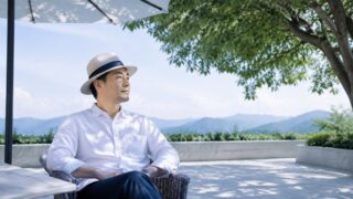 帽子と日傘と木陰で日差しを避ける穏やかな屋外風景
