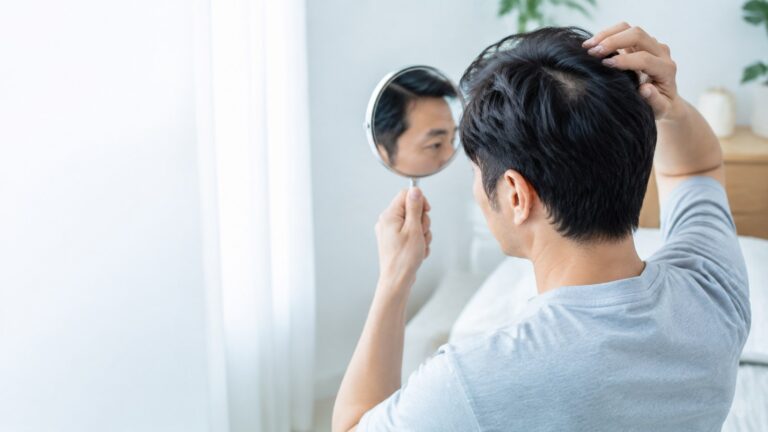 鏡で髪の状態を落ち着いて確認する日本人男性