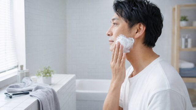洗顔後にシェービングフォームを頬へ塗る日本人男性