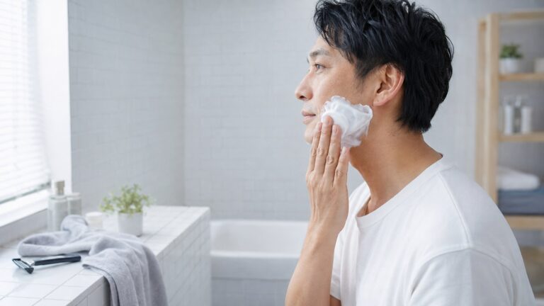 洗顔後にシェービングフォームを頬へ塗る日本人男性