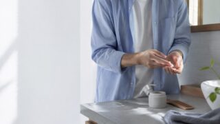 整髪料を少量手に取って使う日本人男性の手元
